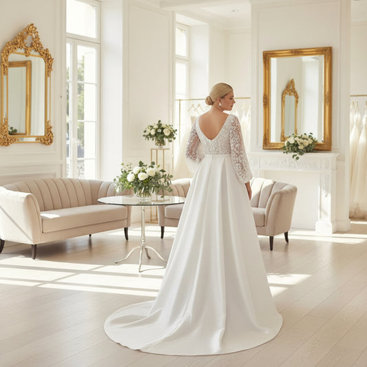 White satin A-line wedding dress with lace sleeves and flowing skirt, belted waist