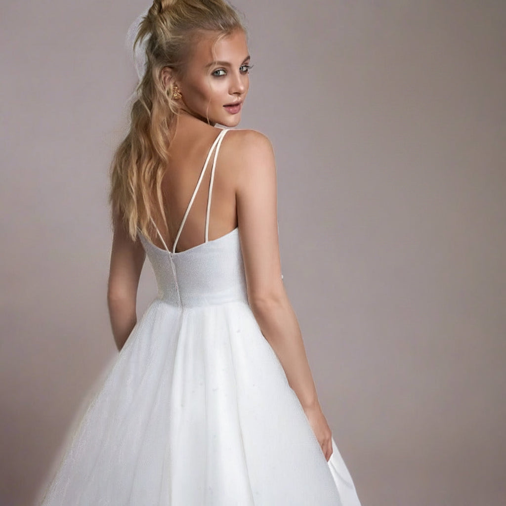 White satin wedding dress with open back and thin spaghetti straps, full skirt