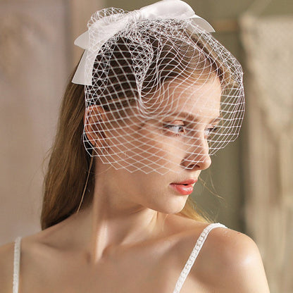 White birdcage veil headband with sweeping side netting and satin bow