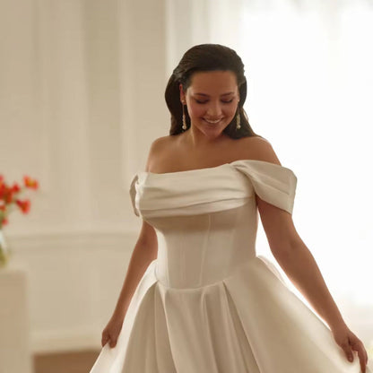 Ivory satin off-shoulder wedding dress with pleated bodice and fitted waist