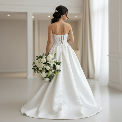 Back view of white satin bridal dress with lace corset and crisscross open-back lacing