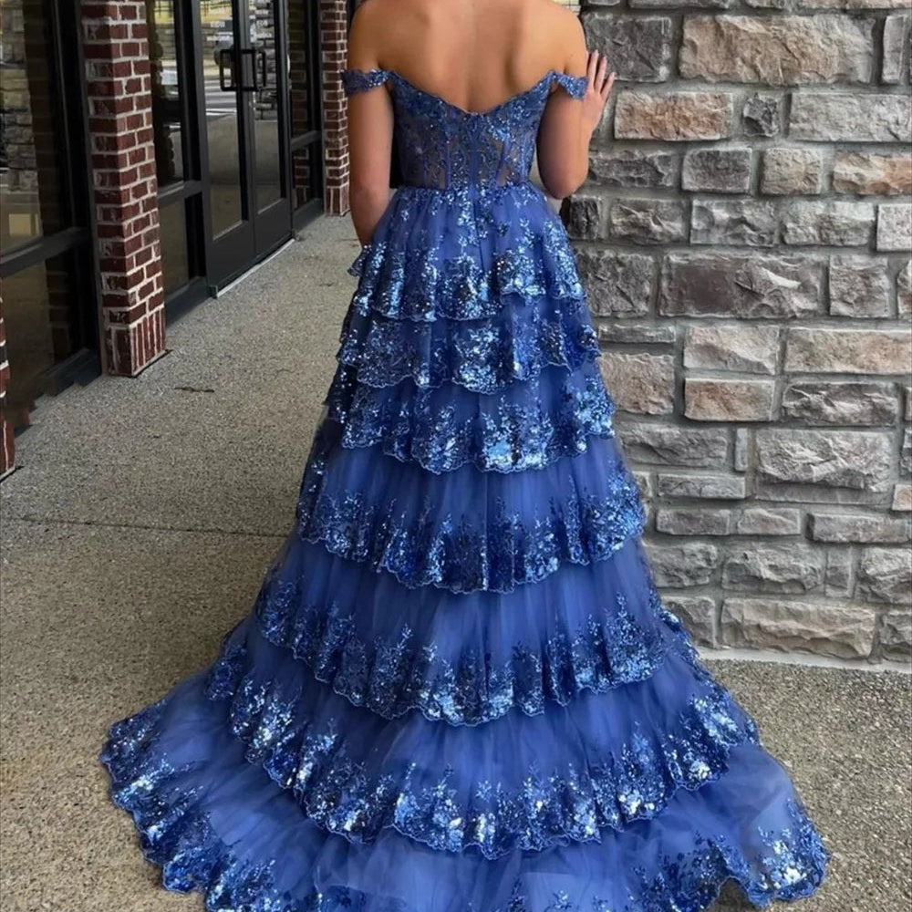 Blue off-shoulder corset-style lace formal gown with glittery tiered skirt and backless detail