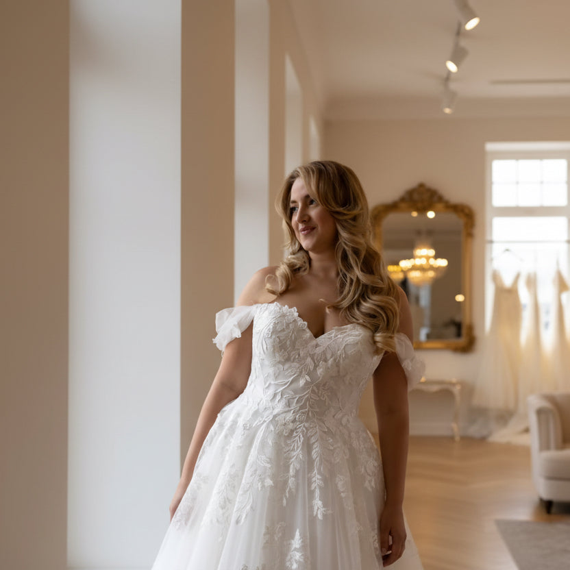 Off-shoulder lace wedding dress close-up with floral appliqué bodice and ruffled sleeves