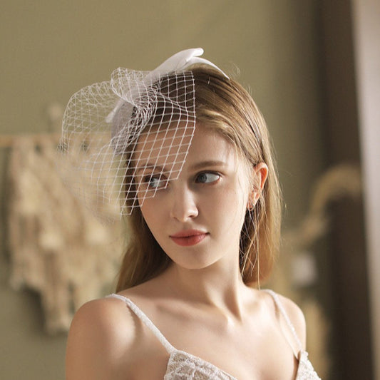 White birdcage veil headband with netting and small satin bow at the side