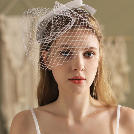 White birdcage veil headband with structured netting and satin bow on top