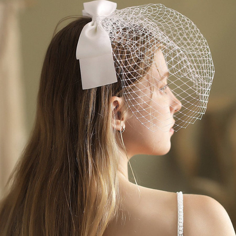 White birdcage veil headband with side-swept netting and satin bow ribbon