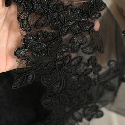 Black lace appliqué on sheer veil edge with detailed floral embroidery