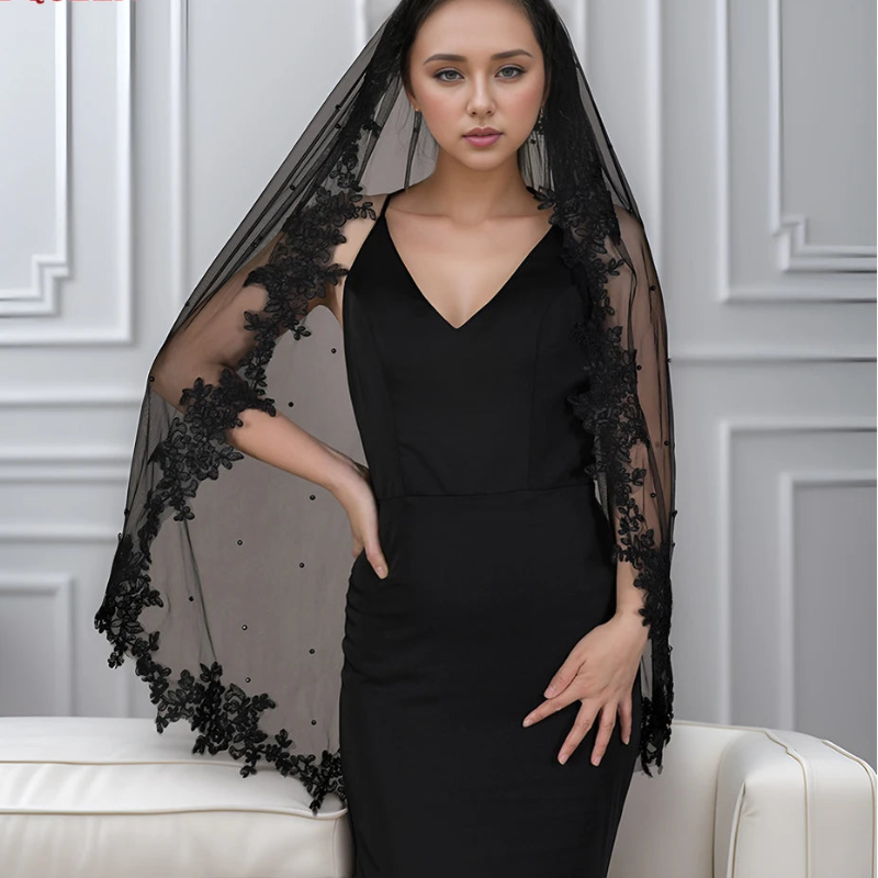 Black wedding veil with lace trim and sheer dotted tulle, draping to shoulders