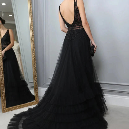 Black A-line evening dress side view with lace bodice and open-back straps, ruffled skirt