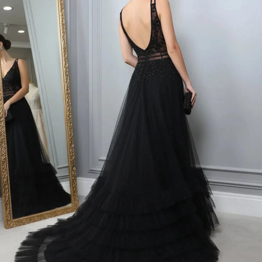 Black A-line evening dress side view with lace bodice and open-back straps, ruffled skirt