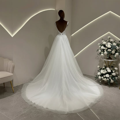 Ivory A-line wedding dress with lace bodice and flowing tulle skirt, rear view on mannequin