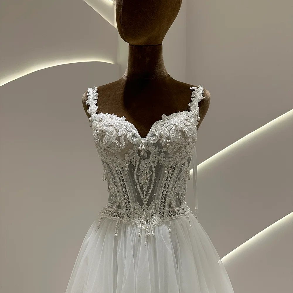 Ivory boho wedding dress with ornate lace corset bodice, beaded details, and tulle skirt