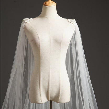 Ivory bridal cape veil with off-shoulder tulle and flower appliques at neckline