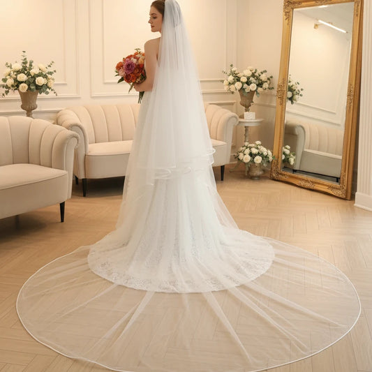 White cathedral-length bridal veil with satin-edged border and flowing tulle layers