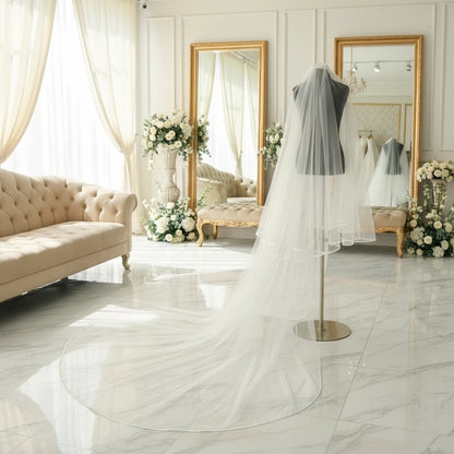 White cathedral-length bridal veil on mannequin with long layered tulle and satin edge
