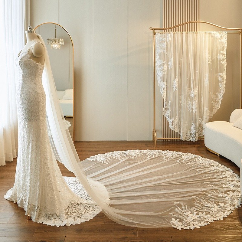 Ivory lace-edged cathedral veil with flowing tulle, petal-cut hem and floral appliques