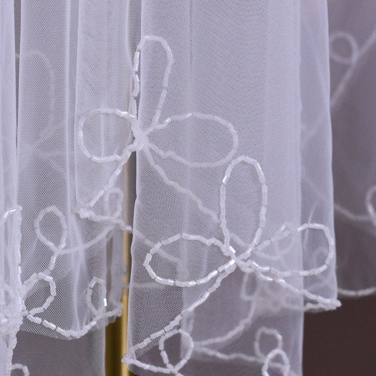 Sheer tulle veil panel with white floral embroidery and bead-like detail