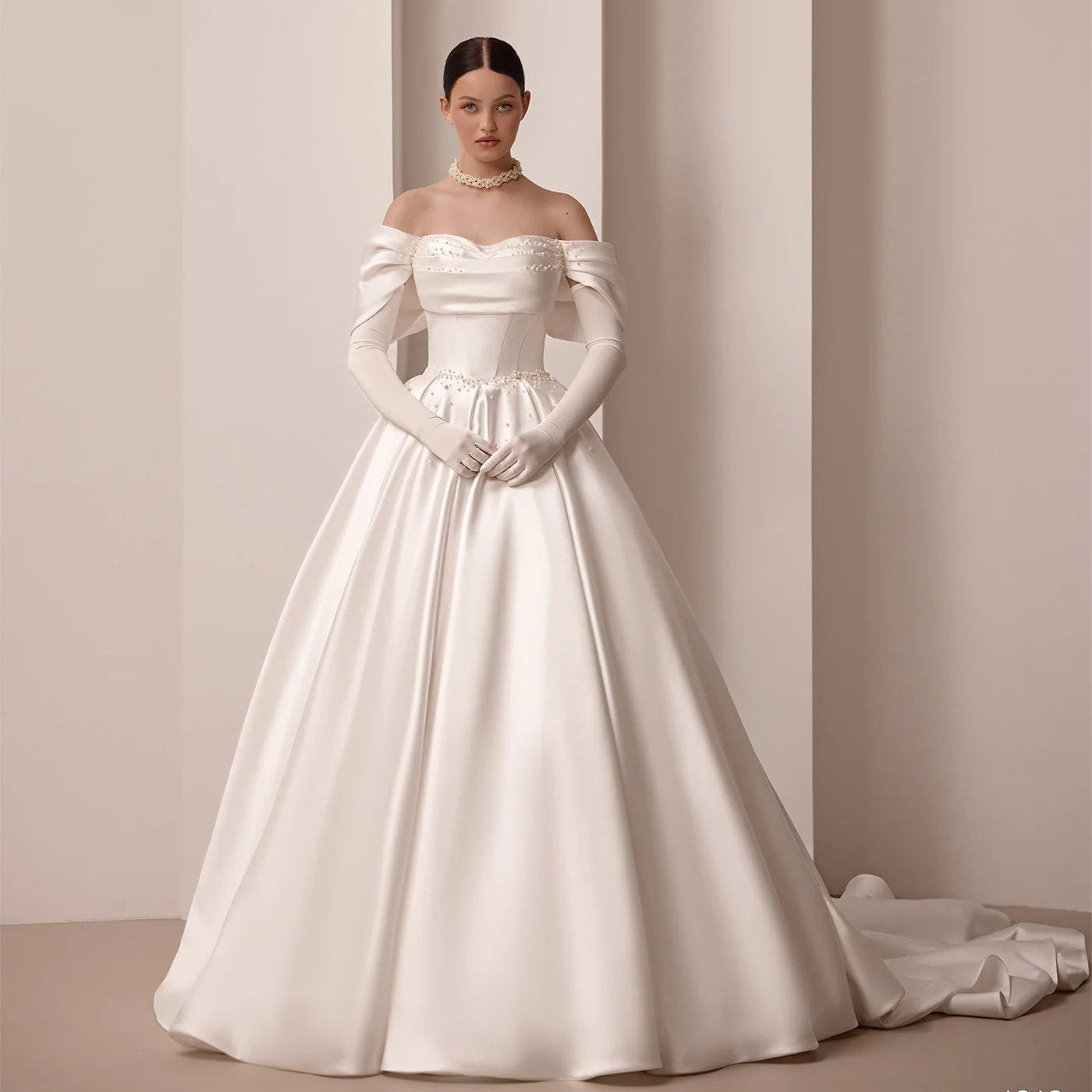 Ivory off-shoulder satin bridal gown with embroidered waist detail and A-line skirt