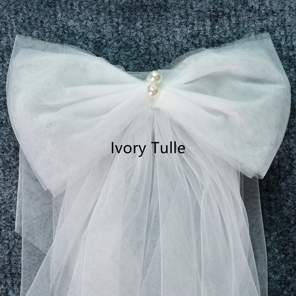 Ivory tulle shoulder bow with gathered net fabric and pearl center
