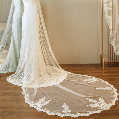 Ivory lace-edged wedding veil, single-tier cathedral length with extended hem