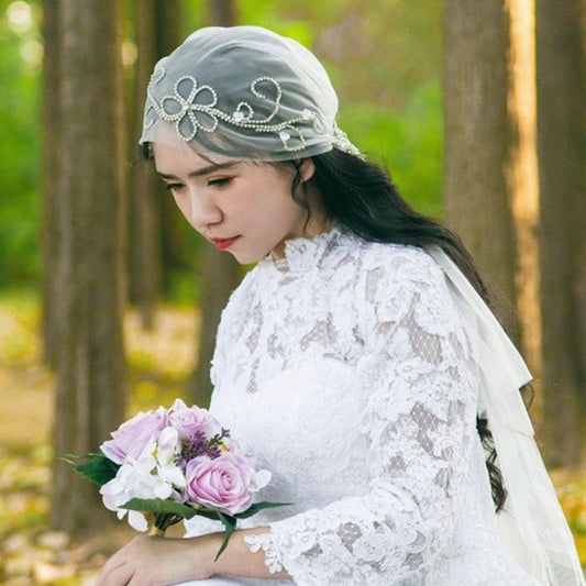 Ivory bridal veil with crystal bow-style cap detail and sheer tulle coverage