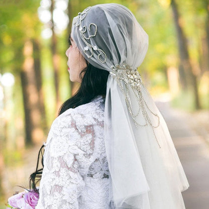 Ivory bridal veil with crystal-embellished cap and flowing tulle drape