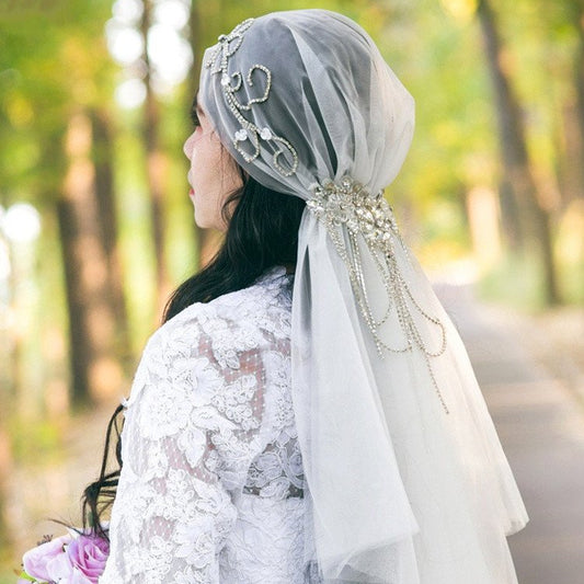 Ivory bridal veil with crystal-embellished cap and flowing tulle drape