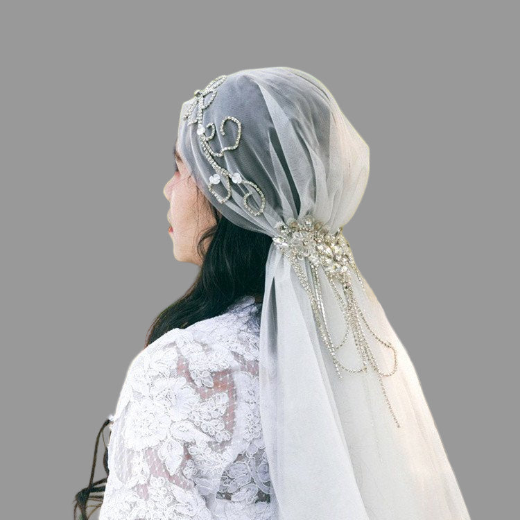 Ivory bridal veil cap with ornate crystal scrollwork and long tulle drape