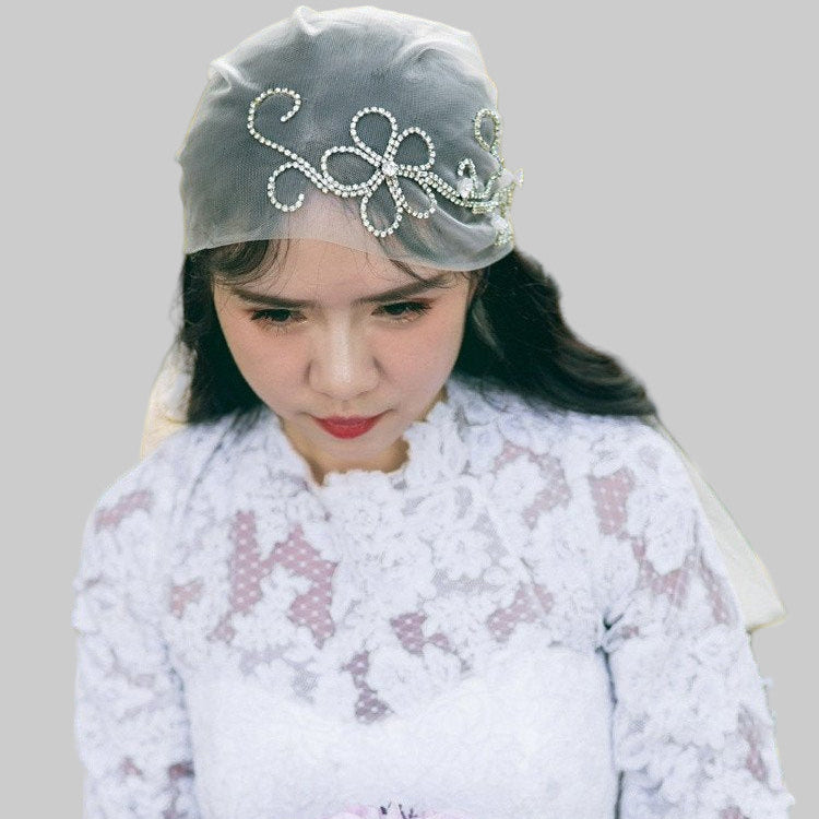 Ivory bridal veil with crystal bow headpiece on sheer tulle