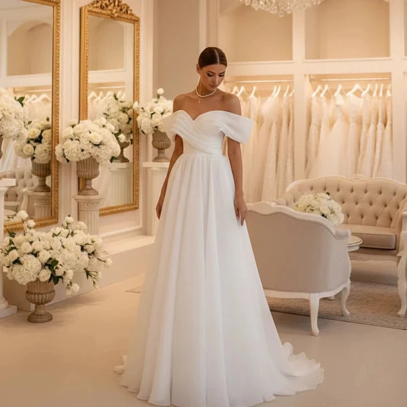 White off-shoulder bridal corset gown with sweetheart neckline and flowing skirt