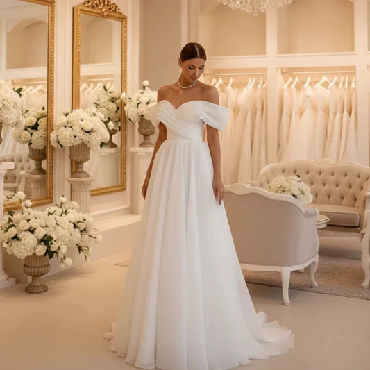 White off-shoulder bridal corset gown with sweetheart neckline and flowing skirt