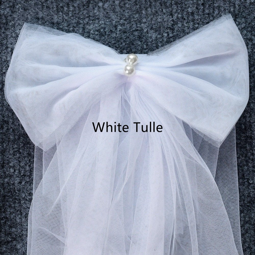 White tulle shoulder bow with gathered fabric and pearl center