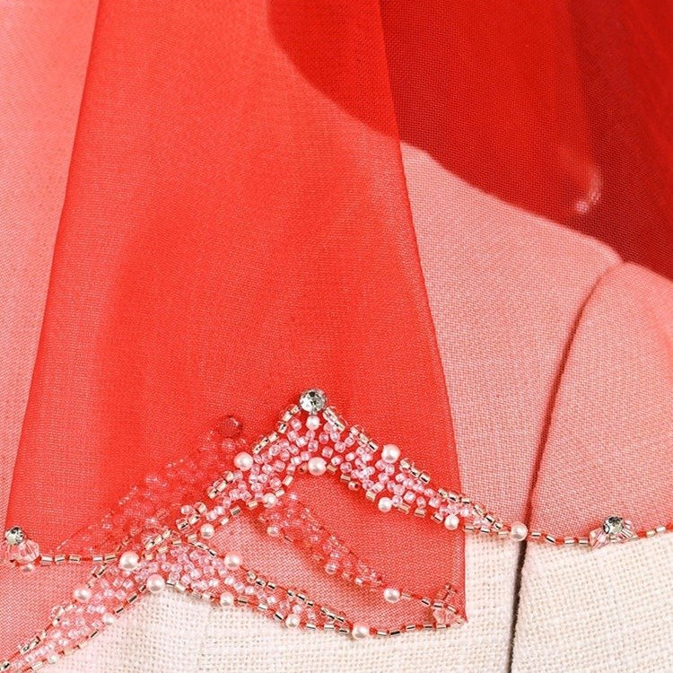 Red sheer veil close-up showing silver beaded, pearl-trimmed scalloped border