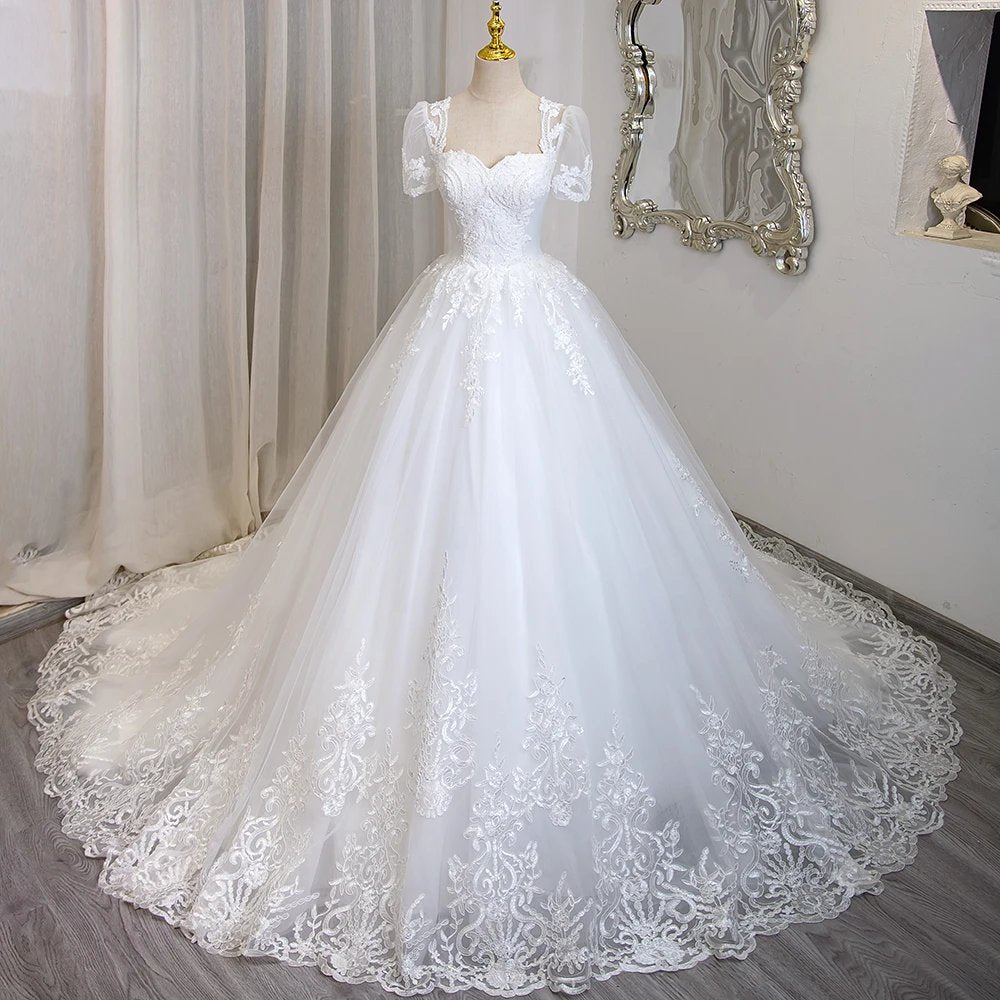 Ivory beaded lace bridal gown with short sleeves and full ballgown skirt