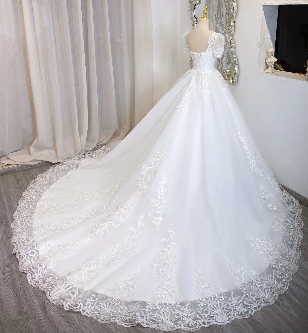 Ivory tulle bridal gown with beaded lace bodice, full skirt, and short lace sleeves