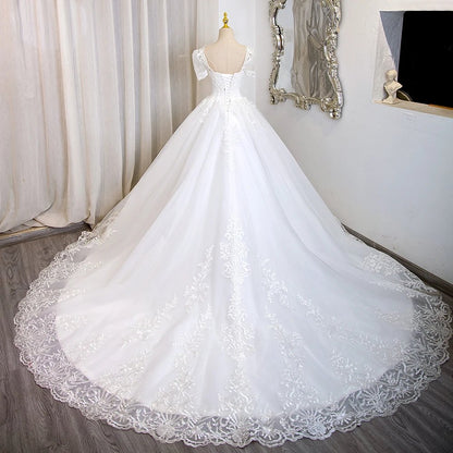 Ivory beaded lace bridal gown with V-shaped bodice detailing and full flared skirt