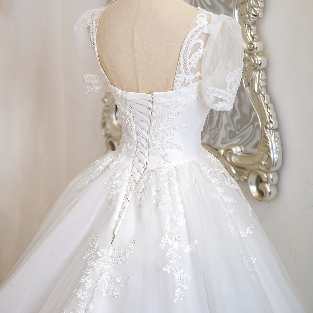 Ivory lace bridal gown back with V-back illusion detail and beaded corset bodice