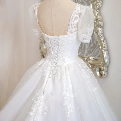 Ivory lace bridal gown back with V-back illusion detail and beaded corset bodice