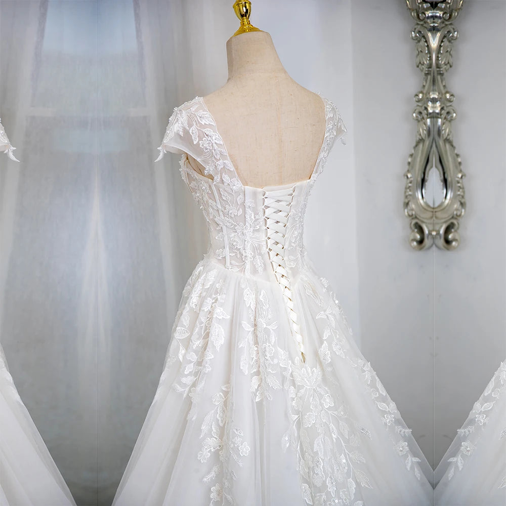 Ivory lace wedding dress with open back, corset lacing, cap sleeves, full skirt