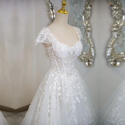 Ivory lace tulle wedding dress with cap sleeves, embroidered bodice and flared skirt