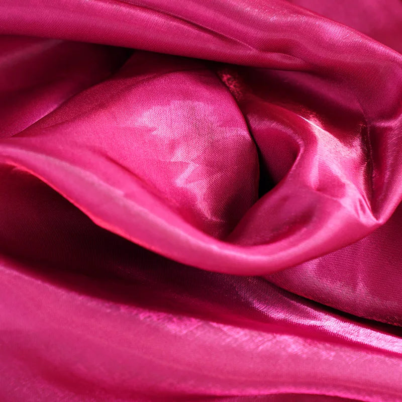 Fuchsia glossy satin fabric close-up with soft folds and sheen