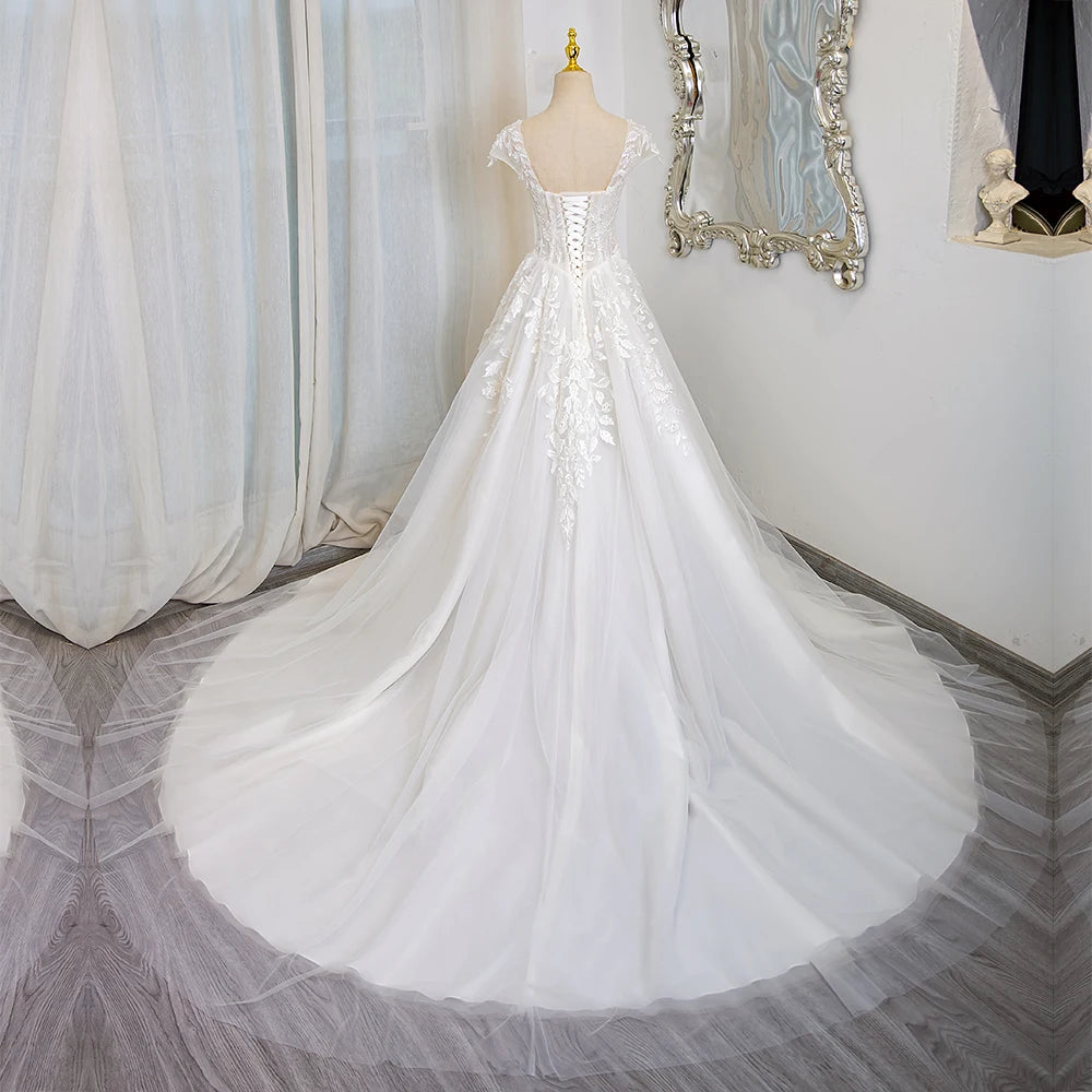 Ivory lace wedding dress with cap sleeves, corset bodice, cascading tulle skirt