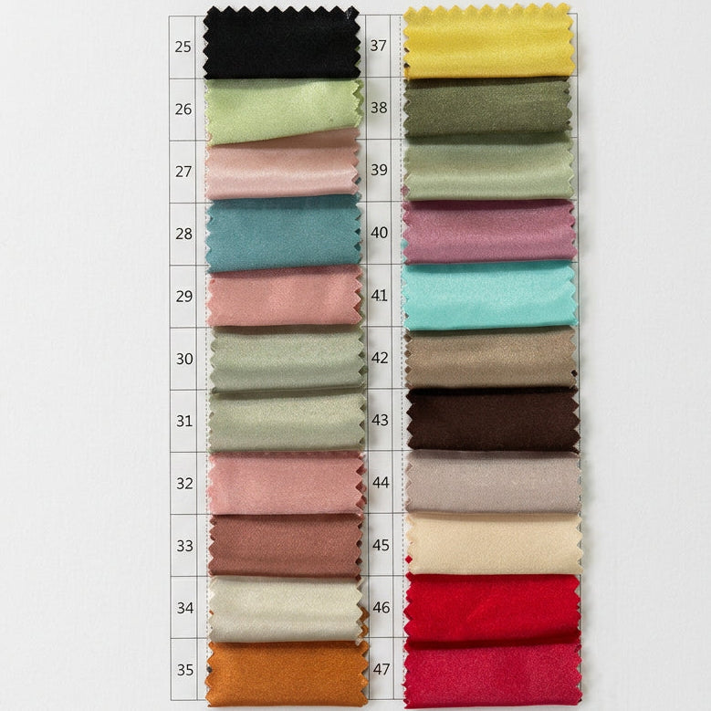 Assorted satin fabric swatches in pastel and jewel tones on numbered cards