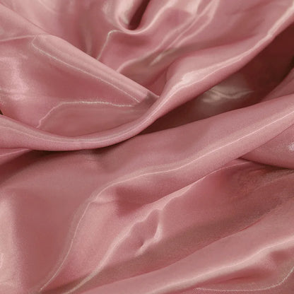 Glossy satin fabric swatch in pale rose with smooth folds and reflective shine