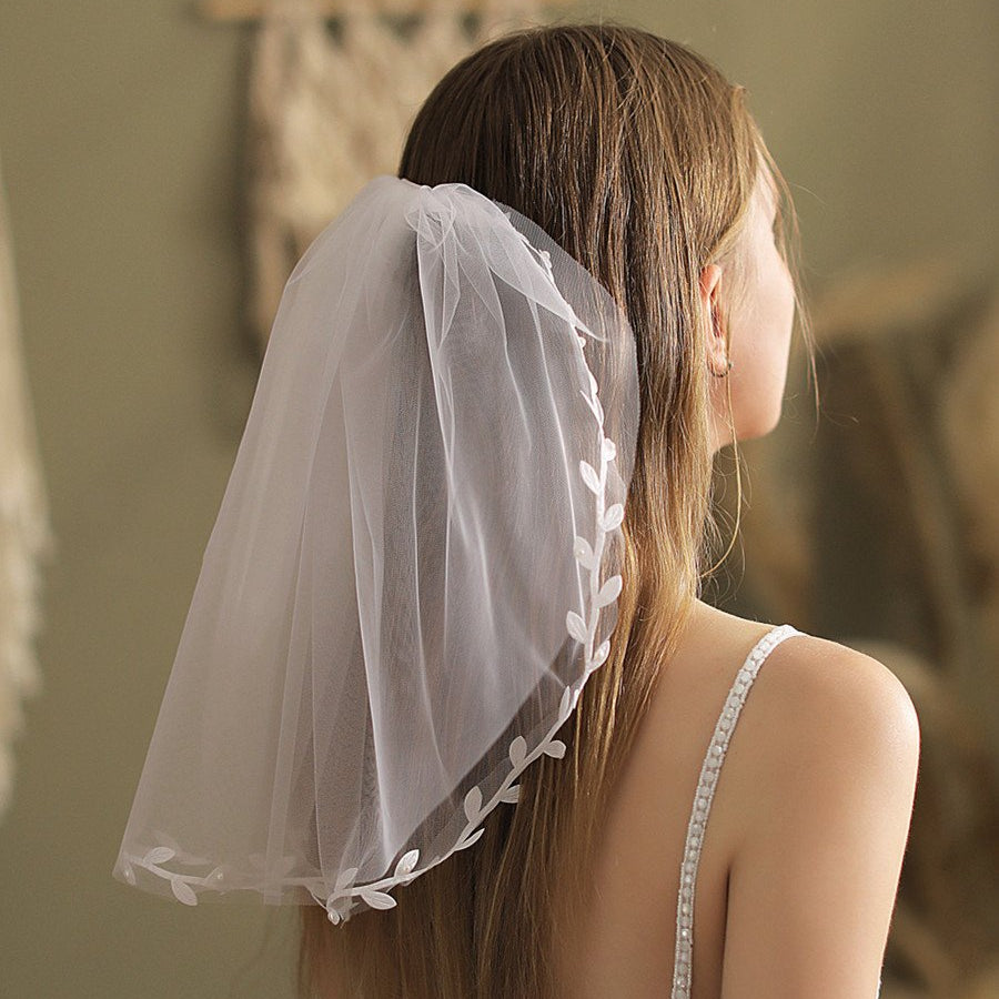 Ivory short veil with lace-edged trim and leaf appliqué on the back of hair