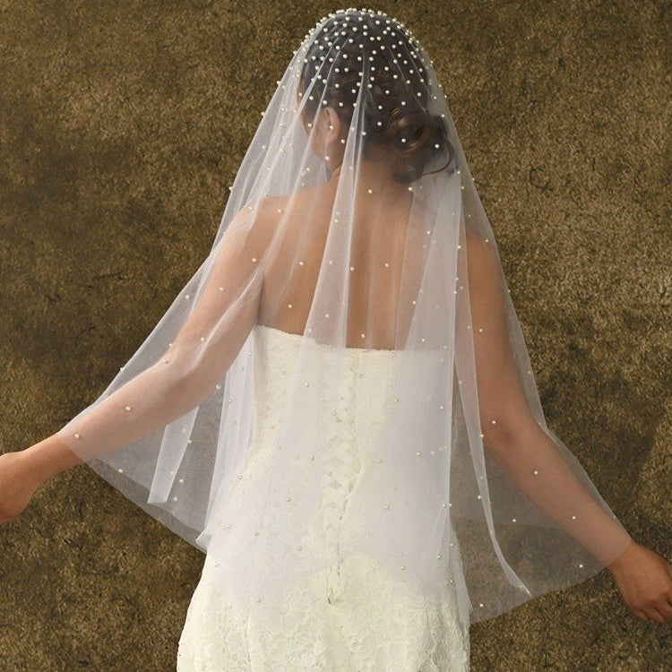 Short sheer veil with pearl beading across the top and flowing tulle layers