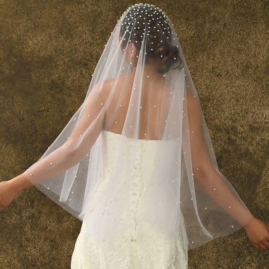 Short sheer veil with pearl beading across the top and flowing tulle layers