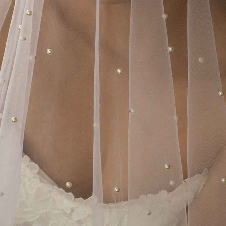 Scalloped hem of sheer veil with small pearl embellishments