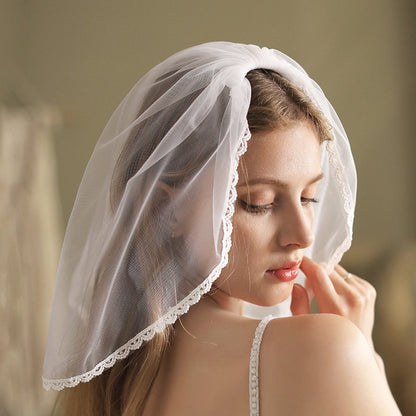 White short bridal veil with scalloped lace border, angled side view