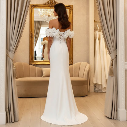 White off-shoulder wedding dress, side view, floral sleeve details and flowing long skirt